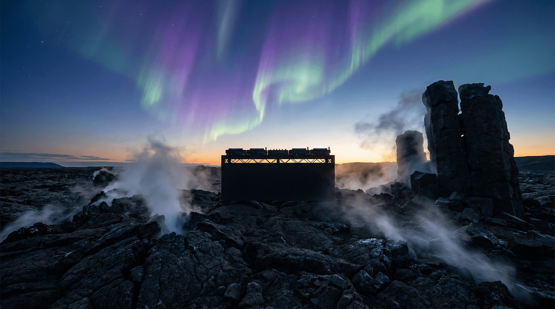 Northern lights over Icelandic landscape with DJ equipment silhouette during twilight