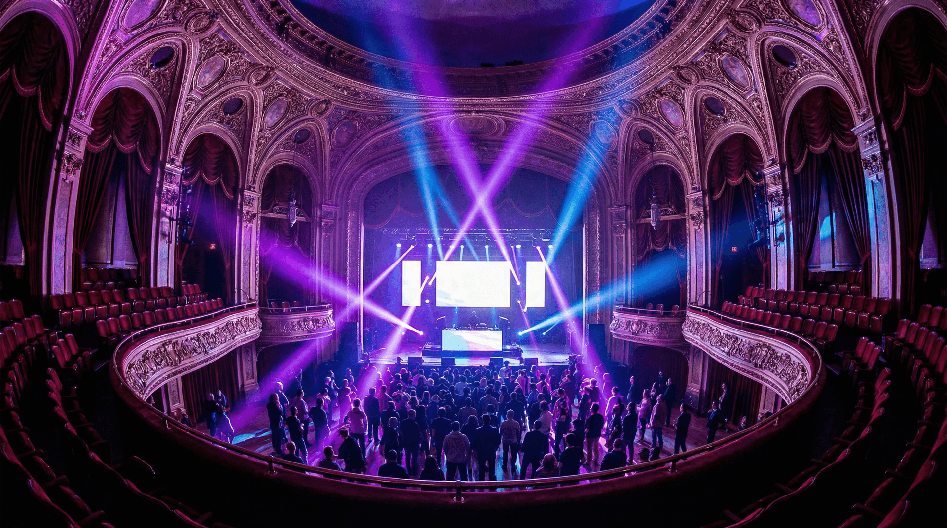 Historic theatre venue with purple and blue stage lighting during an electronic music conference