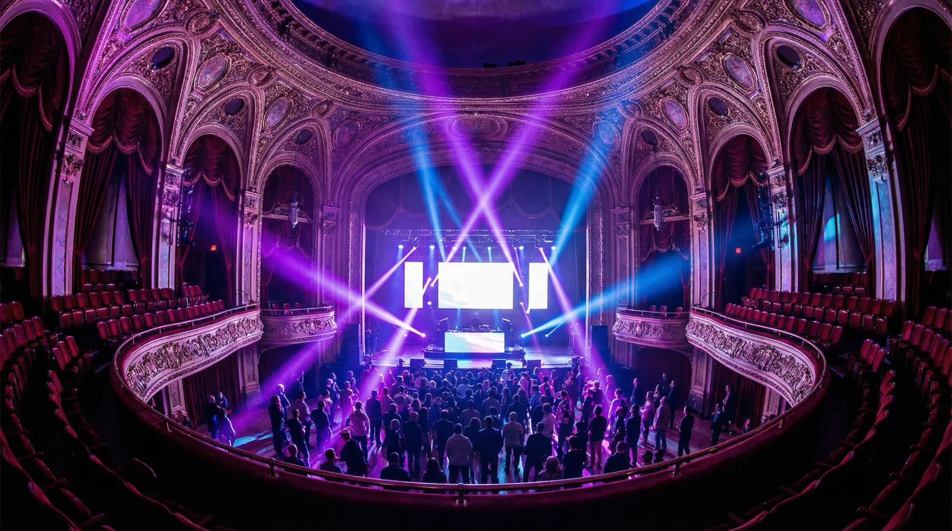 Historic theatre venue with purple and blue stage lighting during an electronic music conference
