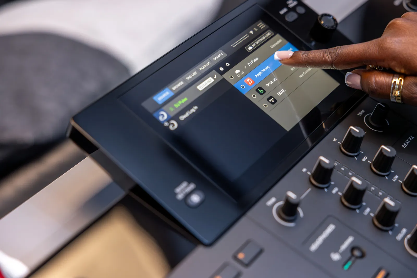 A finger on the 7-inch touchscreen of the AlphaTheta XDJ-AN