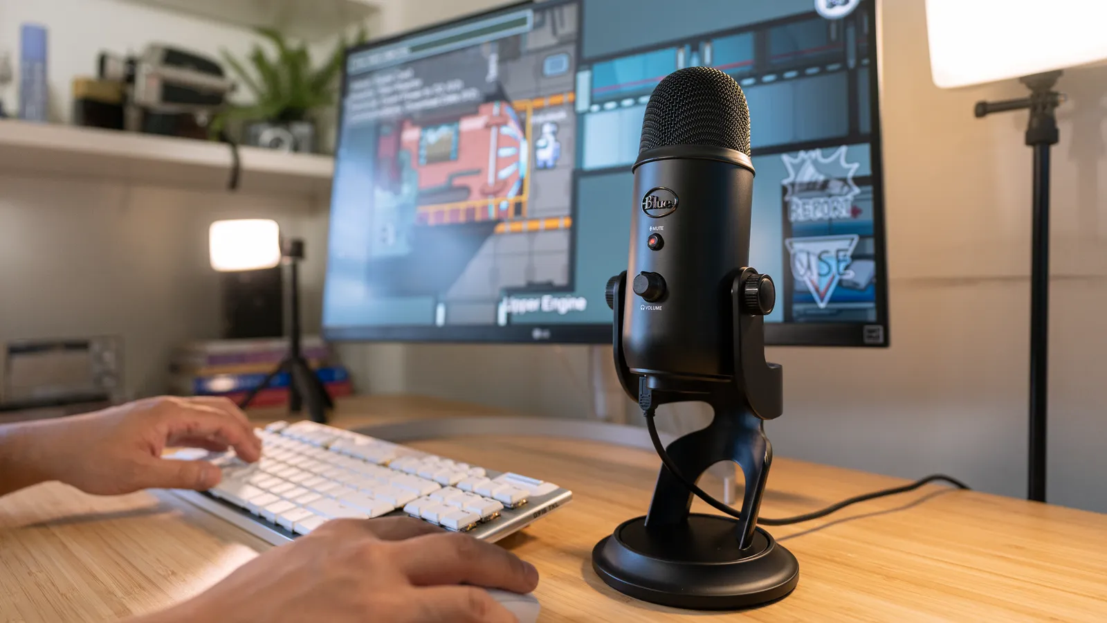 A Logitech Yeti on a desk beside a keyboard and monitor