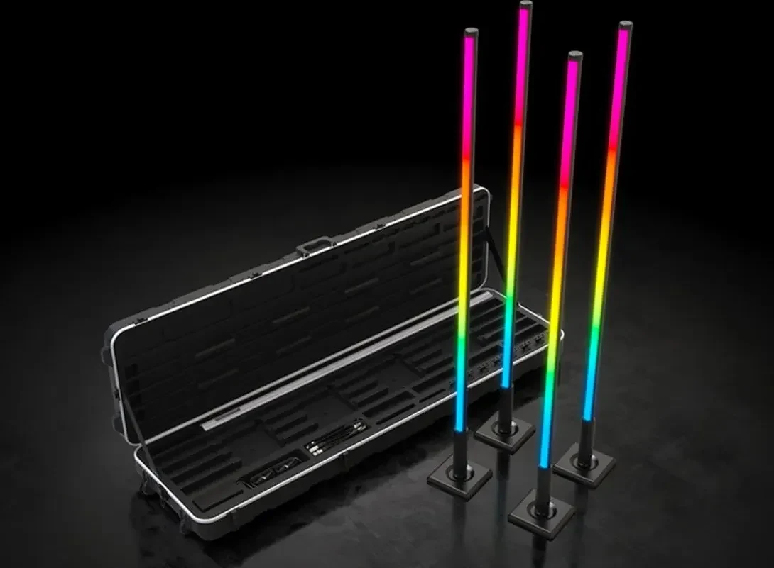 Four Chauvet DJ Freedom Flex Stick X4 sticks lit in colour beside the open moulded case