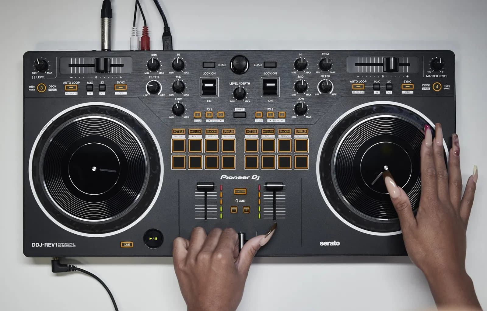 Hands on the jog wheel and crossfader of a Pioneer DJ DDJ-REV1, seen from above