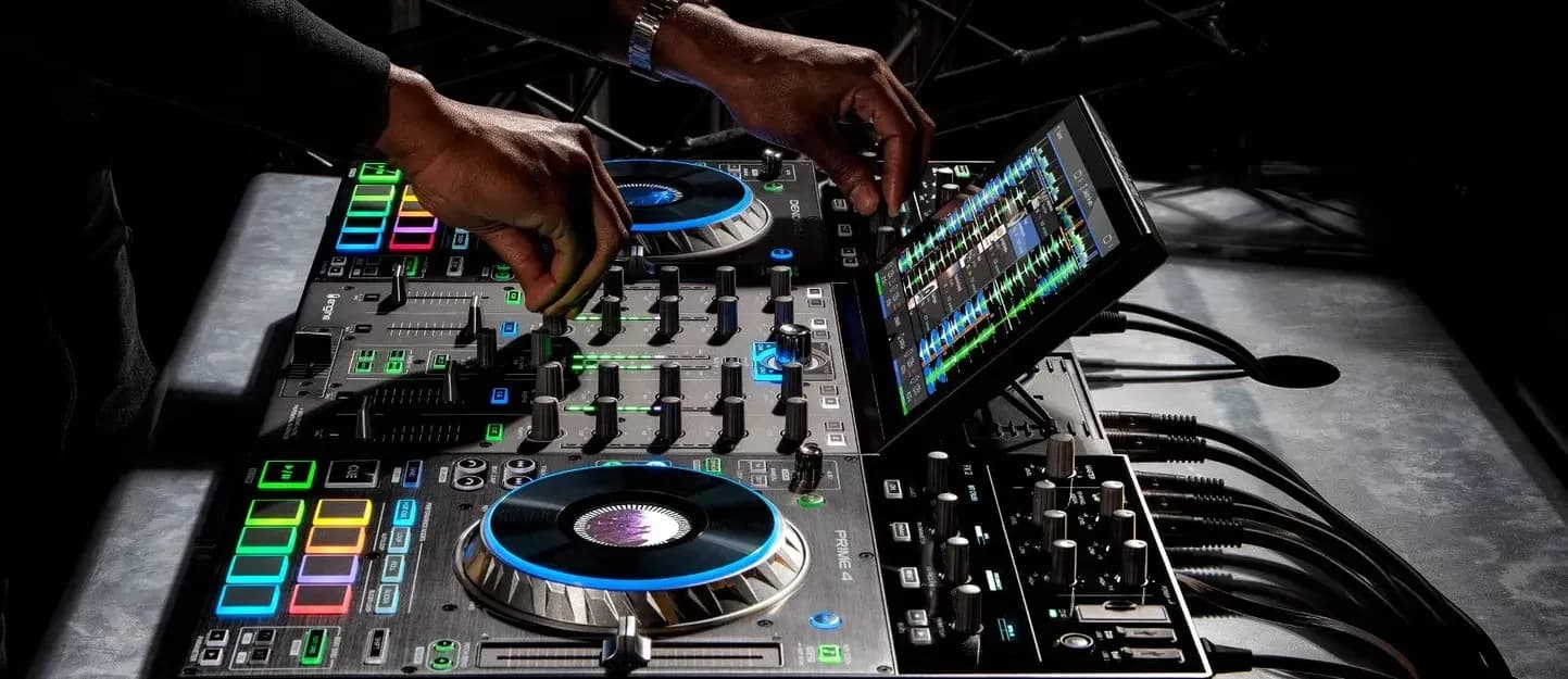 A DJ playing a Denon DJ PRIME 4 with its touchscreen tilted up