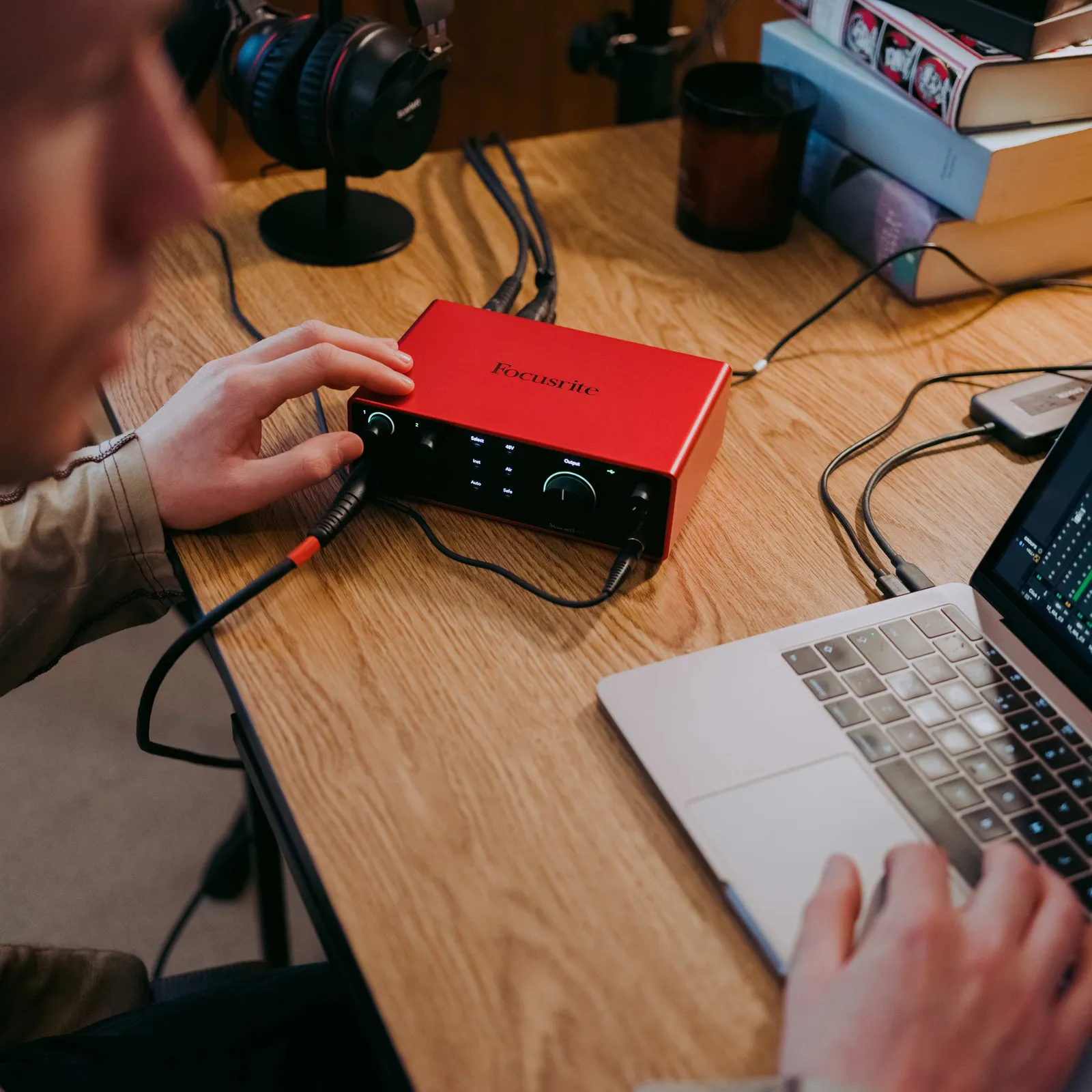 A Focusrite Scarlett 4i4 (4th Gen) in use on a desk beside a laptop