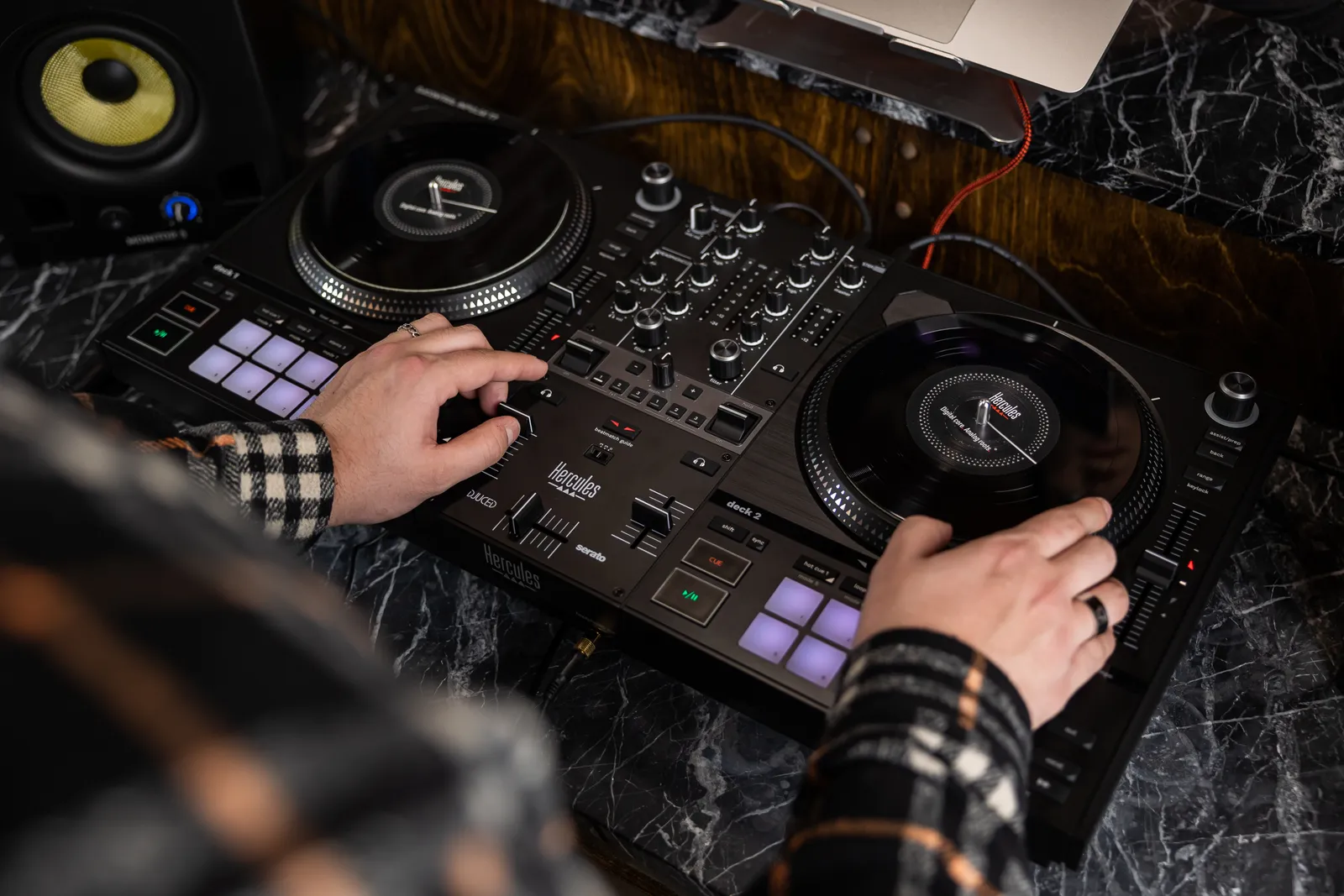 A DJ with both hands on the platters of a Hercules DJControl Inpulse T7, seen from above