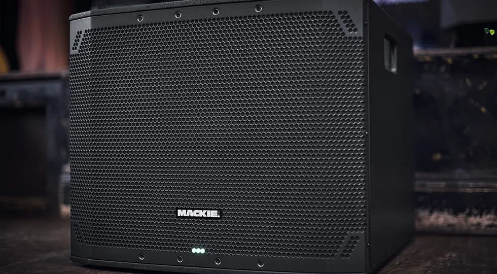 Close-up of the Mackie Thump18Sv4 grille and front LED on a wooden floor