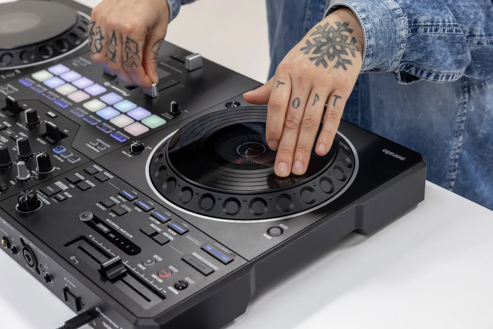 A hand on the jog wheel of the Pioneer DJ DDJ-REV5