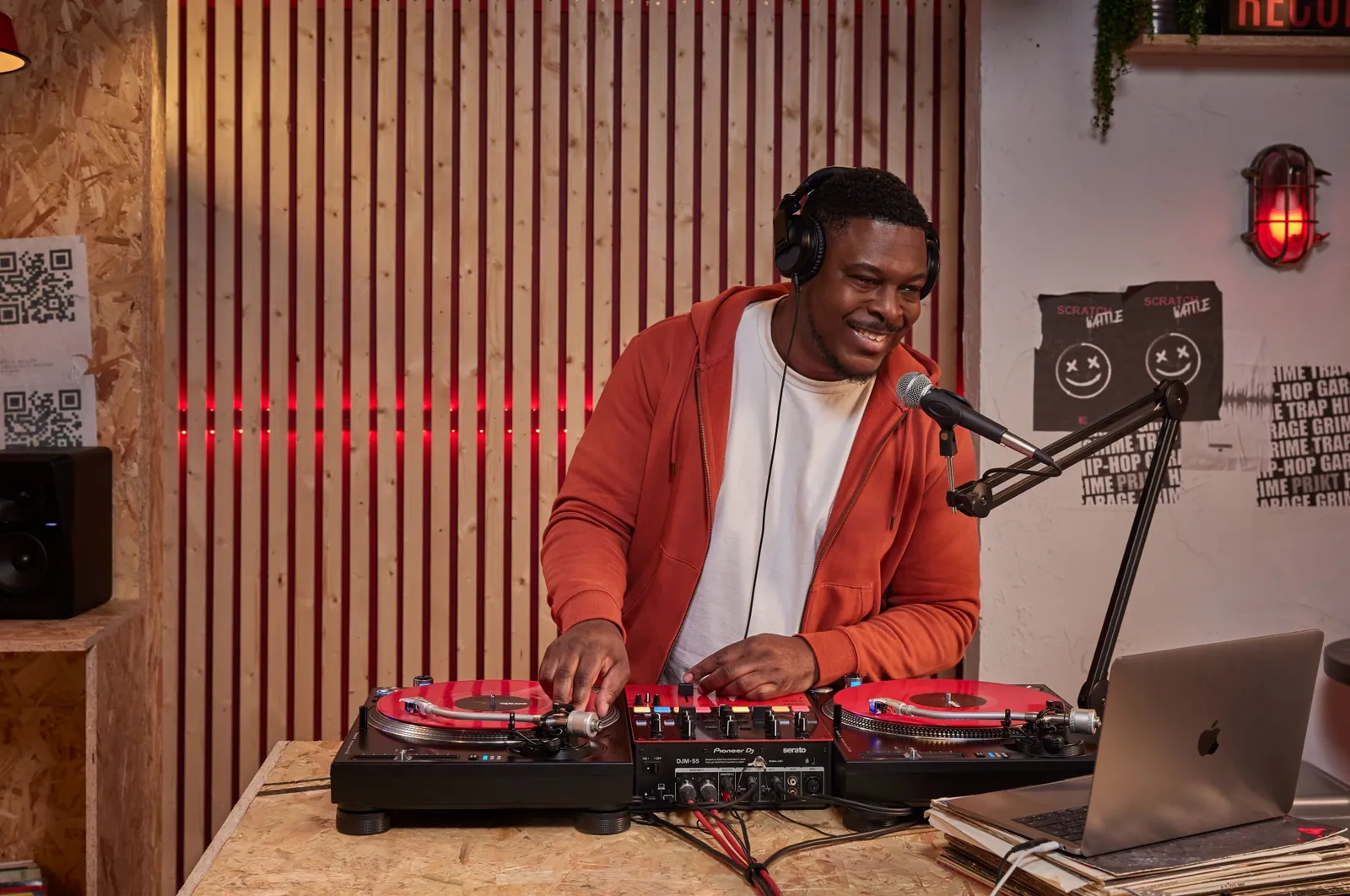 A DJ playing a Pioneer DJ DJM-S5 with two turntables