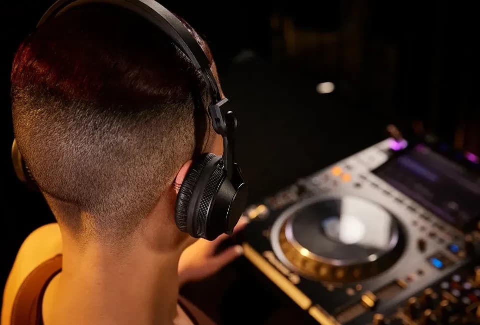A DJ wearing the Pioneer DJ HDJ-CX at a CDJ player