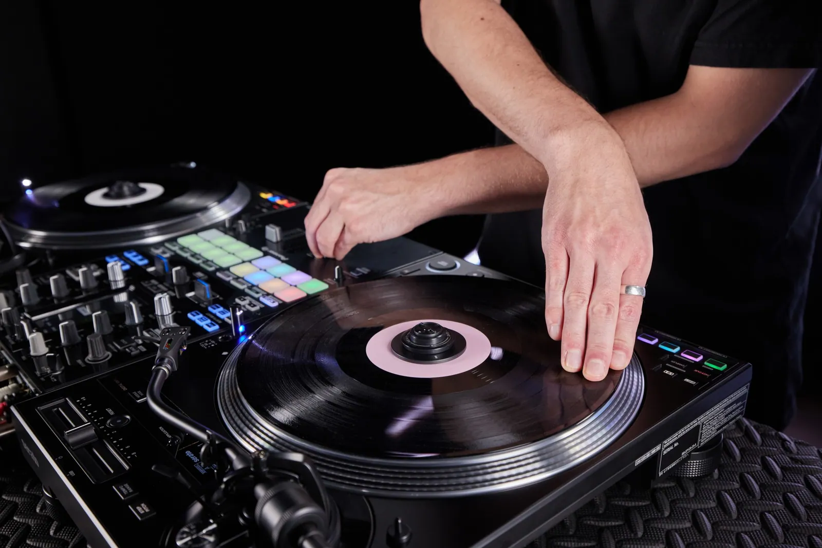 A DJ's hands on the platter and controls of a Pioneer DJ PLX-CRSS12