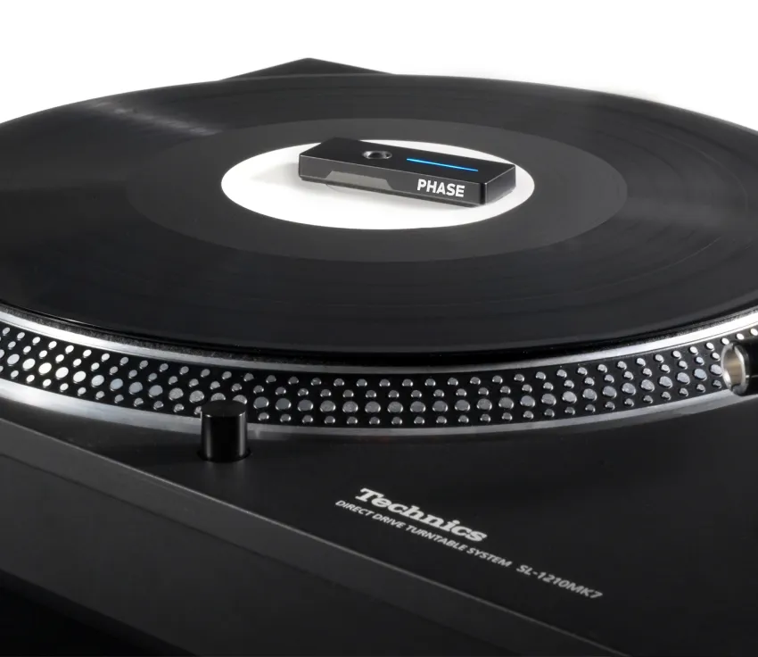 A Phase remote sitting on a record on a Technics turntable