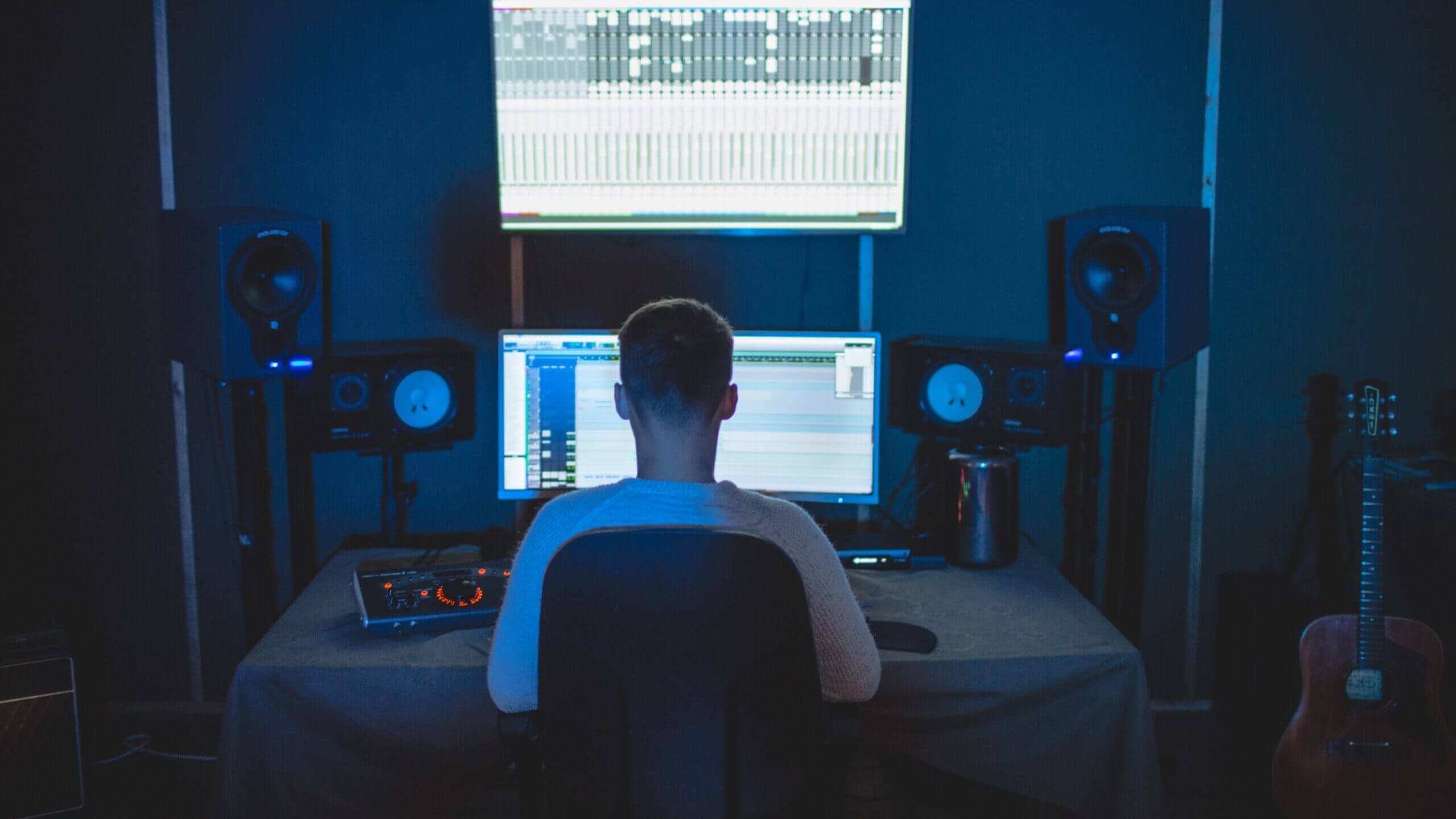 music producer sat at desk listening to music edited
